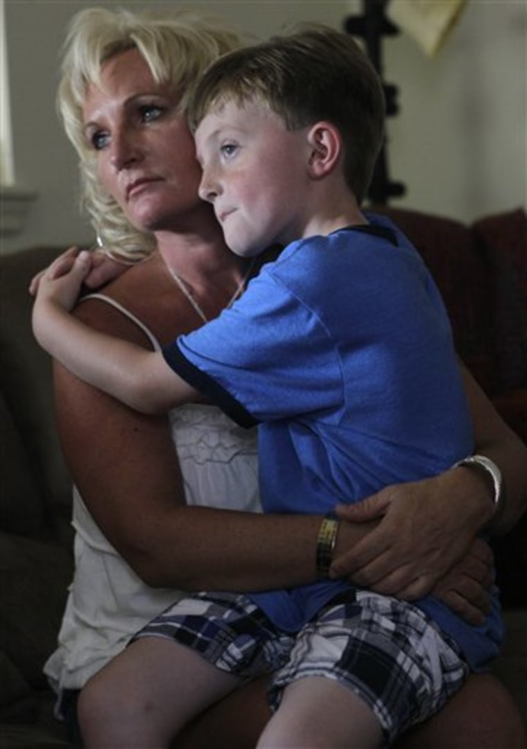 **ADVANCE FOR MONDAY MAY 31** In this Friday, May 14, 2010 photo, Joann Yost holds her son A.J. in Raeford, N.C. Yost's husband and A.J.'s father Tony was killed in Iraq five years ago. (AP Photo/Gerry Broome)